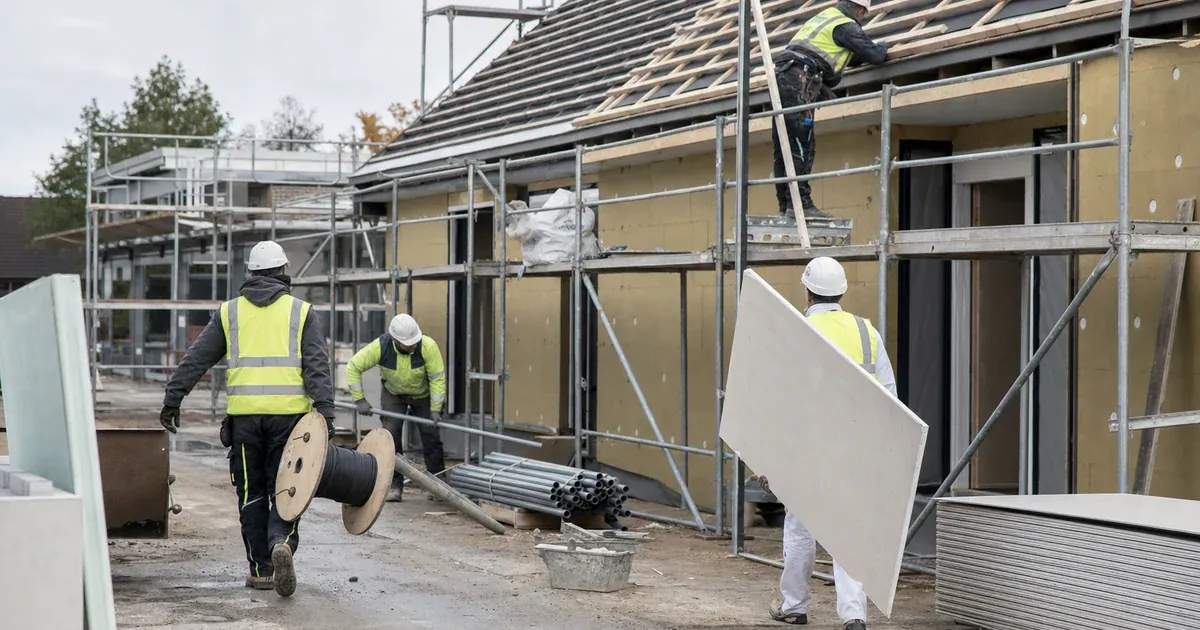 Handwerker verschiedener Gewerke arbeiten gemeinsam auf einer Baustelle